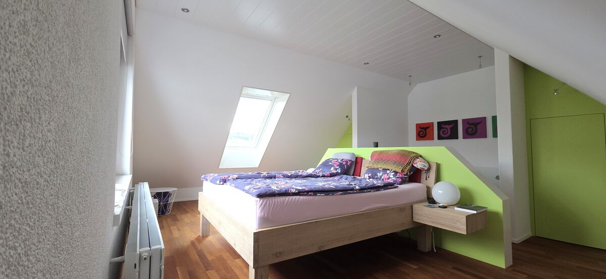 Schlafzimmer im Dachgeschoss mit farbigen Akzenten