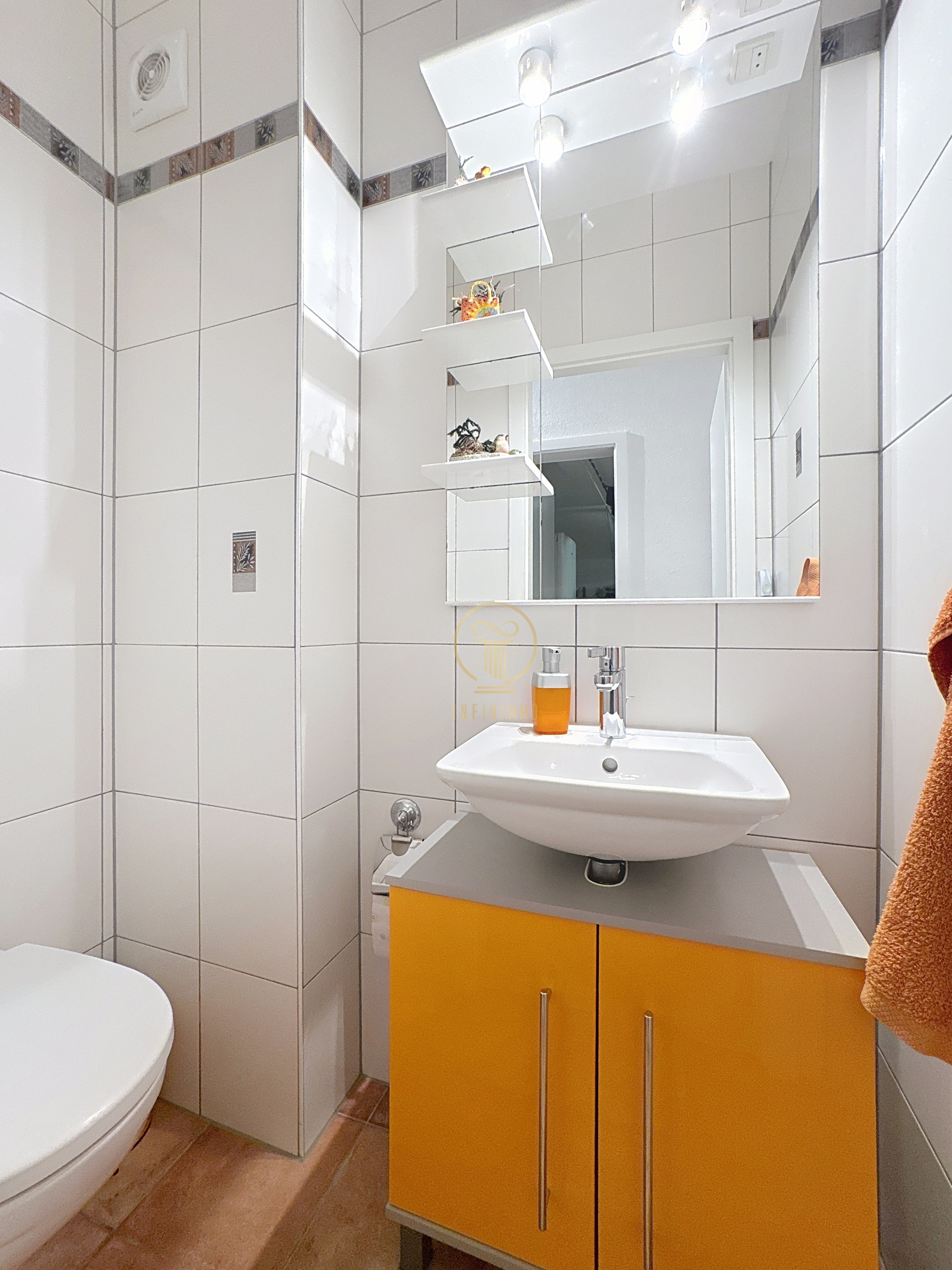 Kleines helles Badezimmer mit Waschbecken und WC