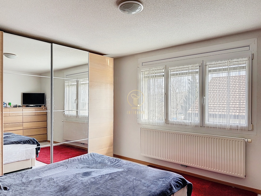 Schlafzimmer mit Kleiderschrank und Fensterfront
