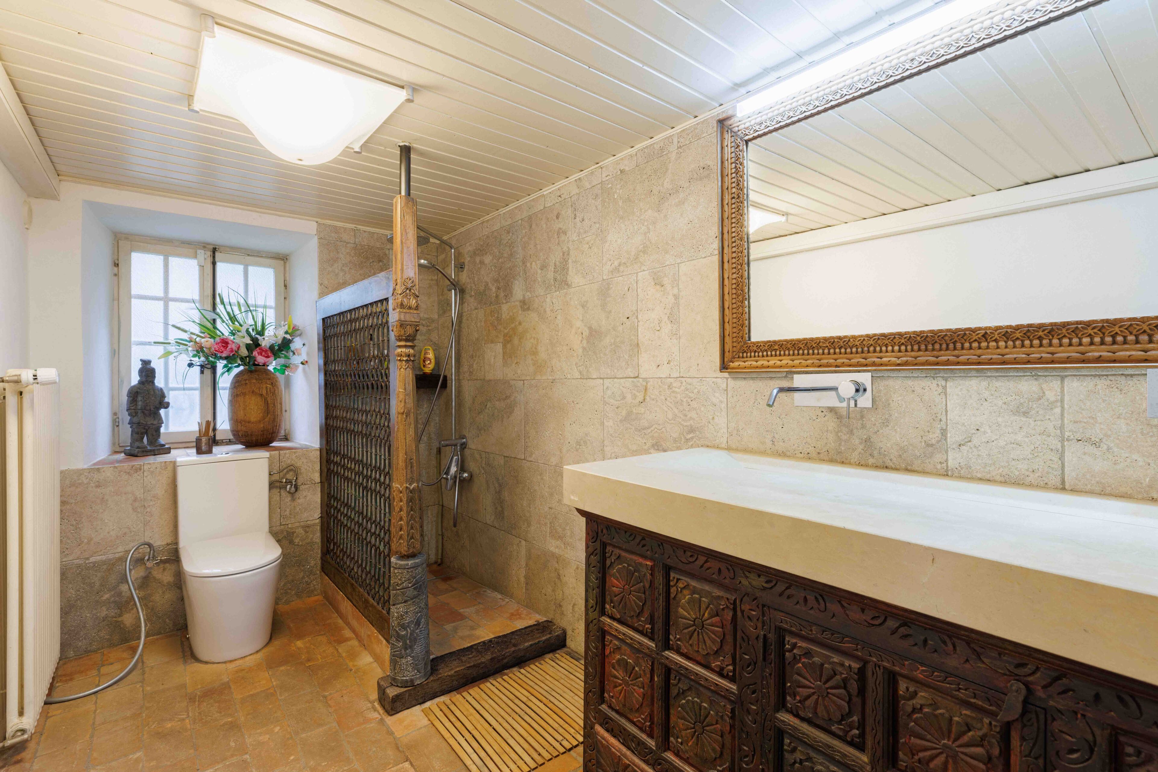 Badezimmer mit Naturstein und Holzdetails