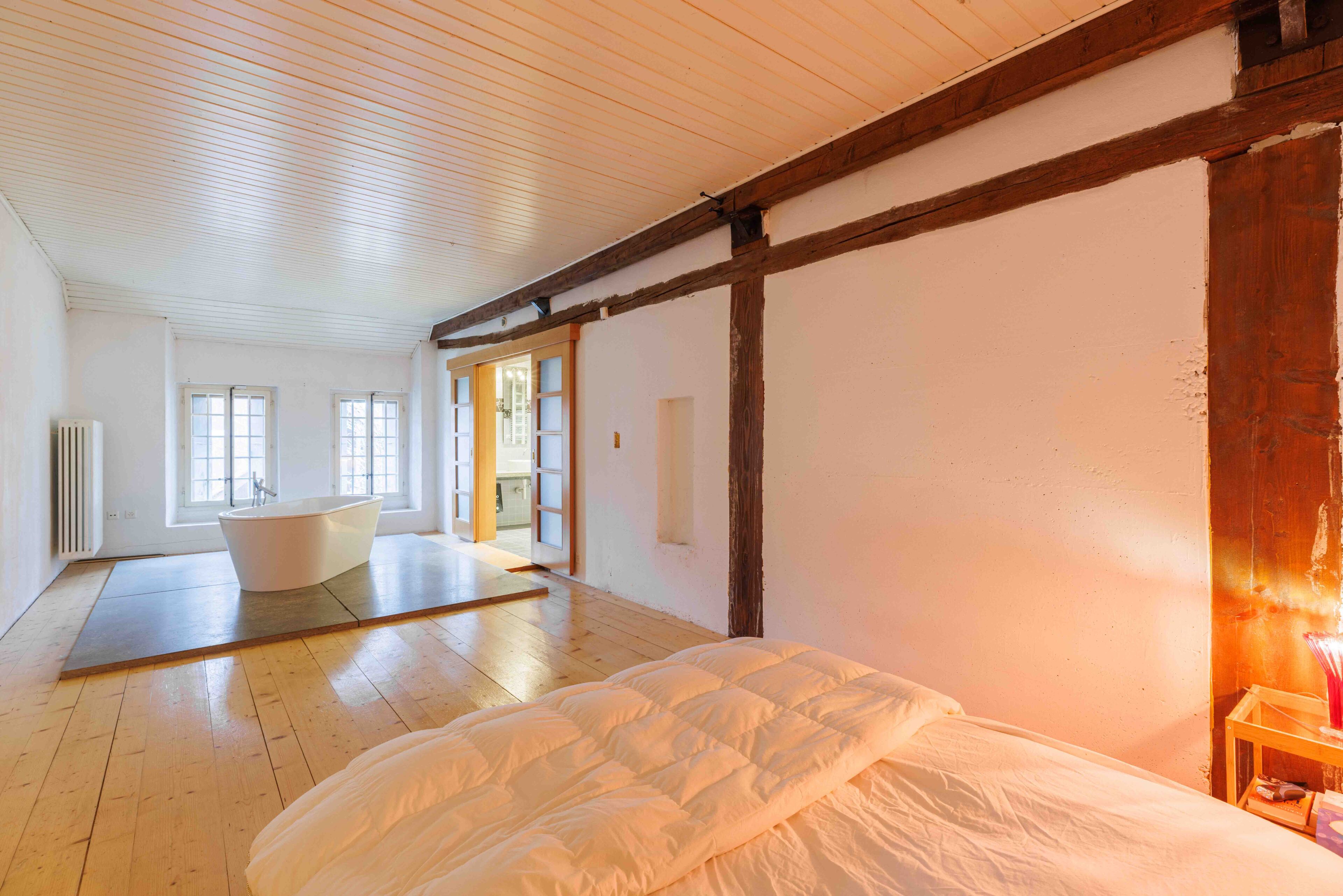 Helles Schlafzimmer mit freistehender Badewanne