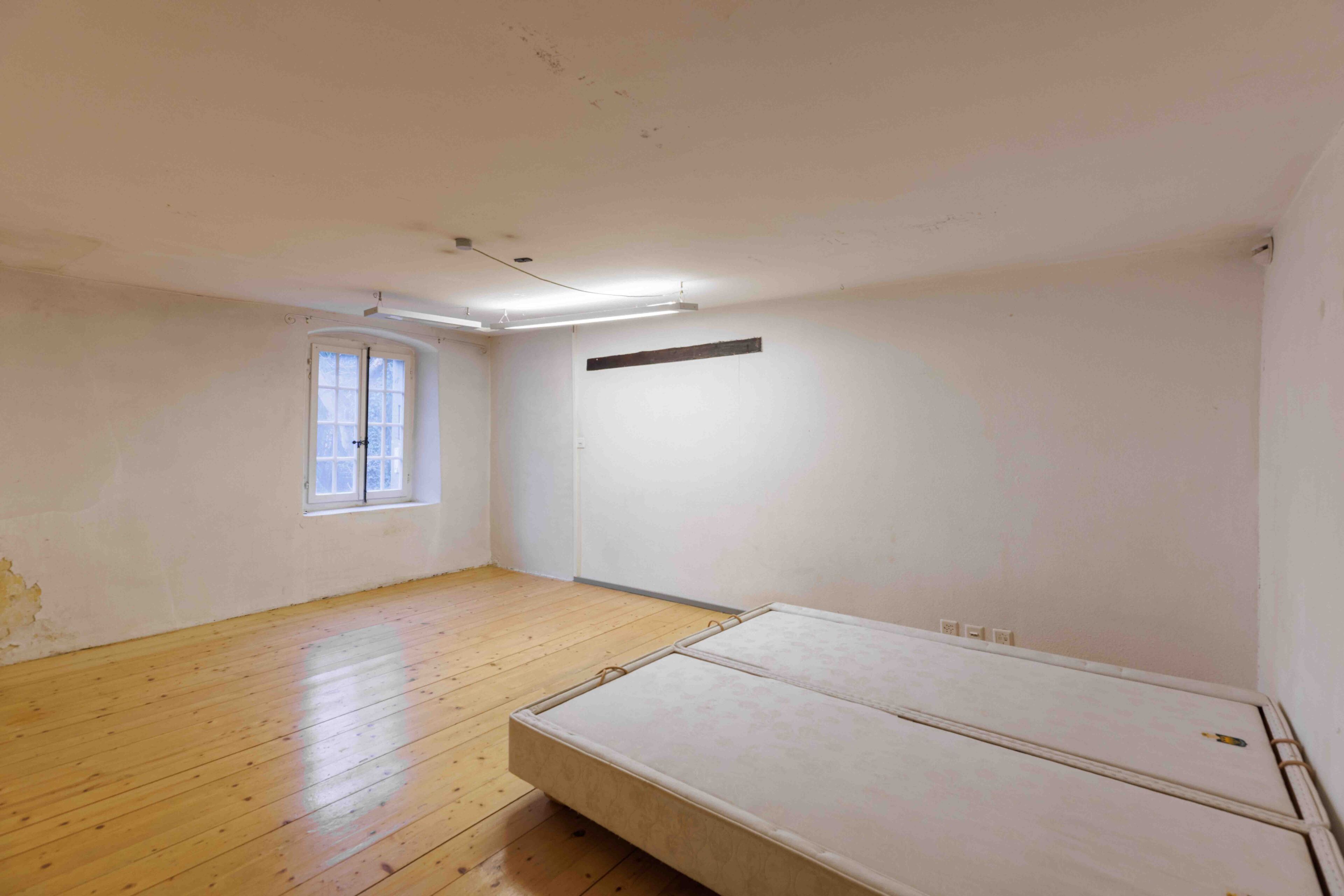 Ein schlichtes, renovierungsbedürftiges Schlafzimmer