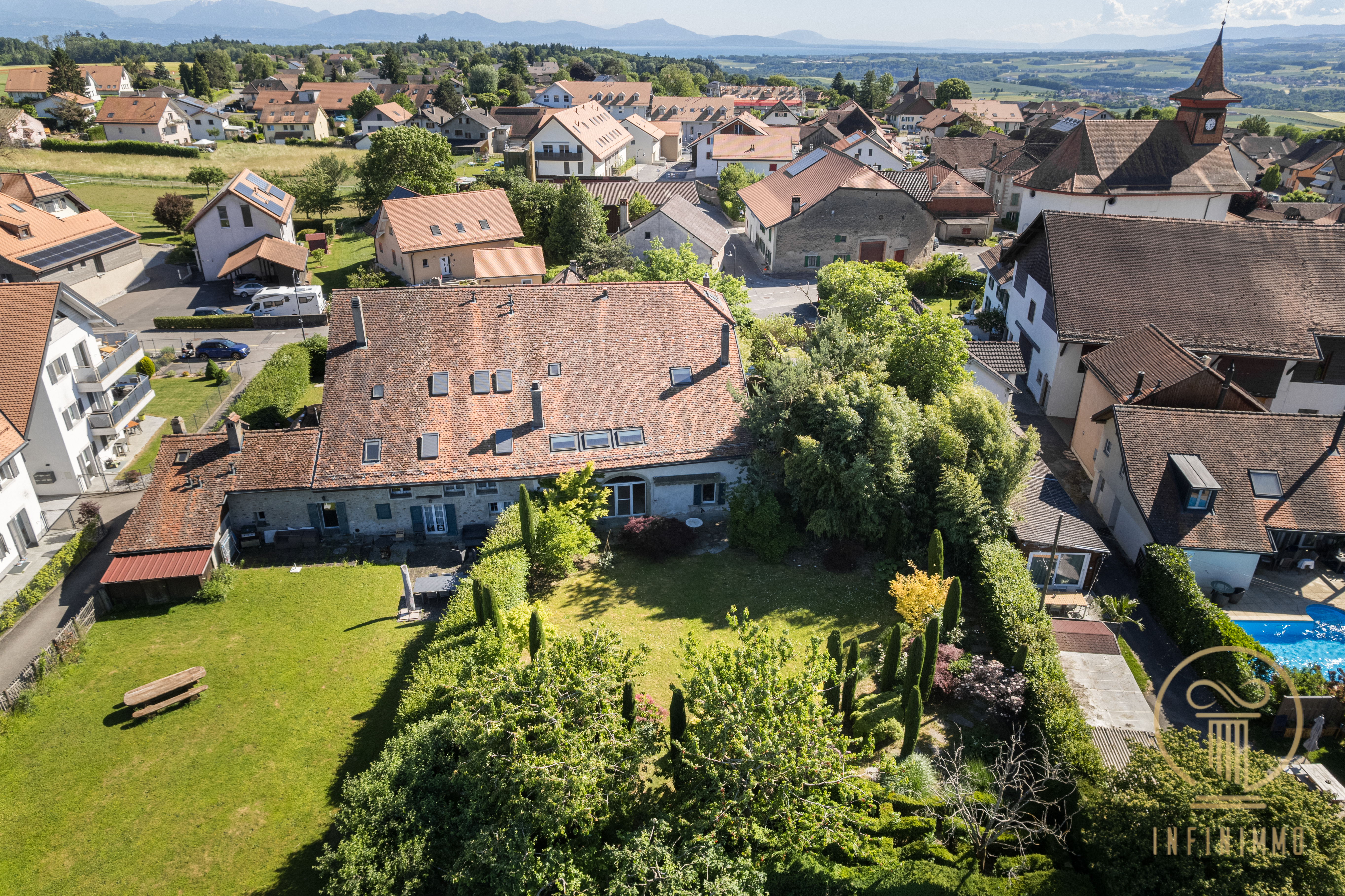 Luftaufnahme eines Wohnquartiers mit Garten und Bergblick
