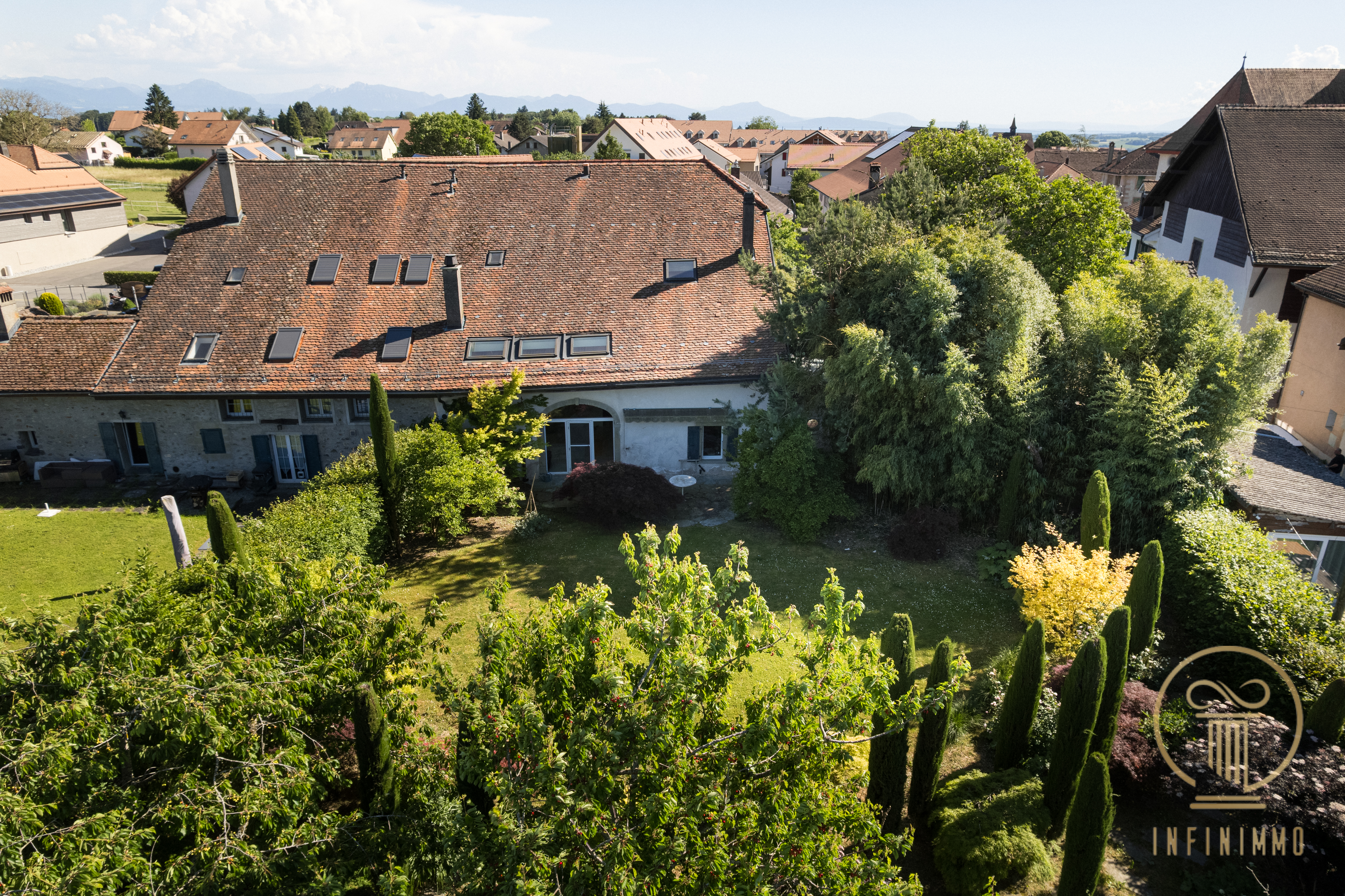 Blick auf Haus und Garten mit Alpenpanorama
