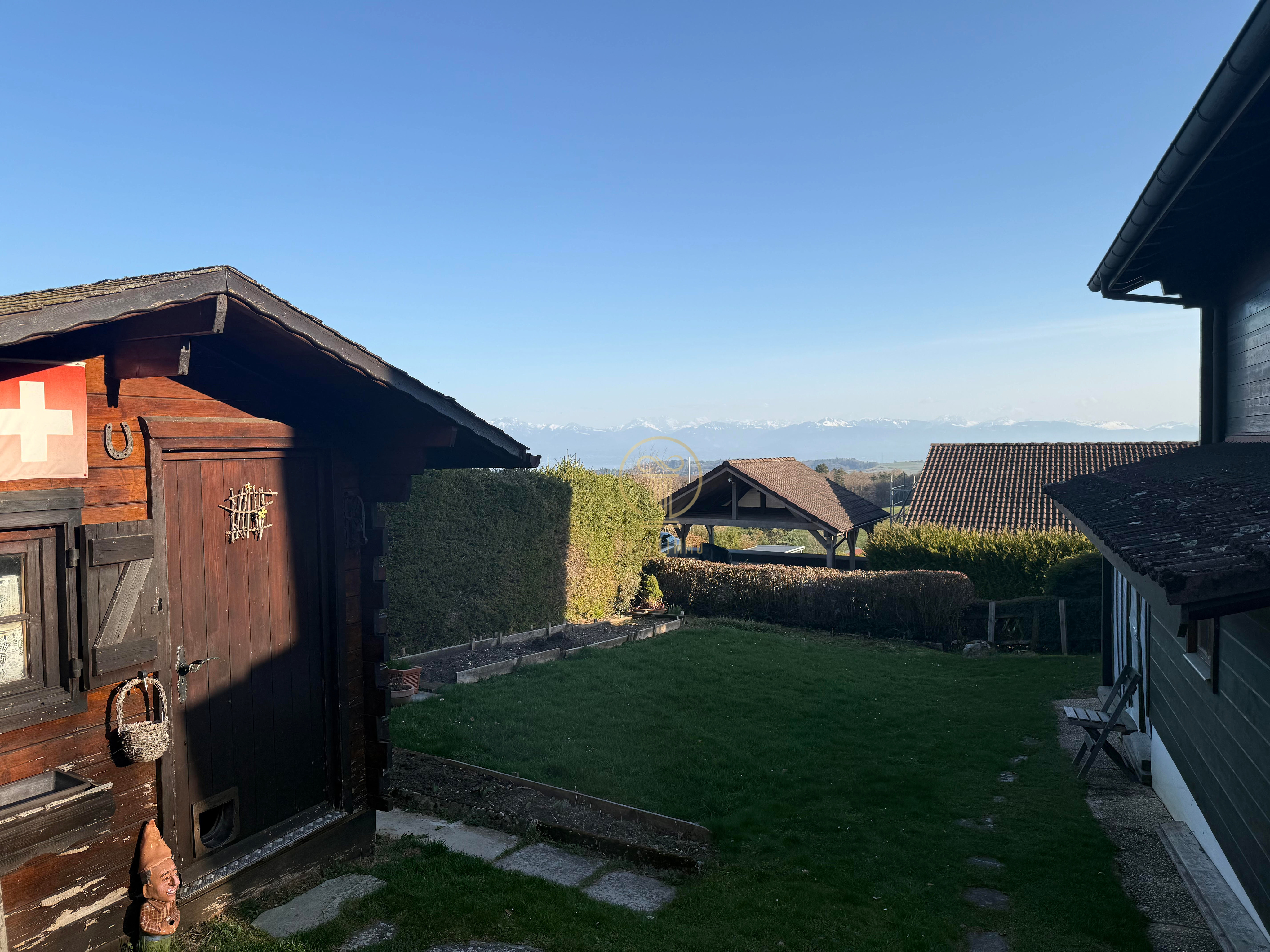 Alpenblick über einen Garten mit Chalet-Charakter