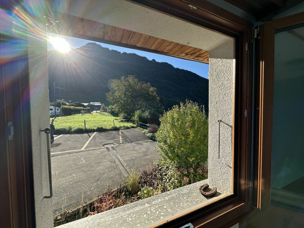 Blick aus dem Fenster auf Berglandschaft und Garten