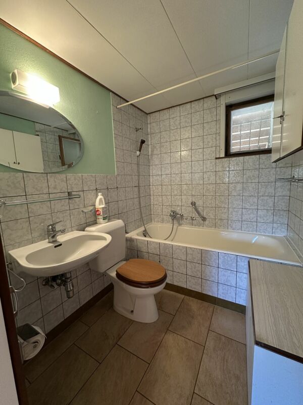 Kleines Bad mit Wanne und Waschbecken
