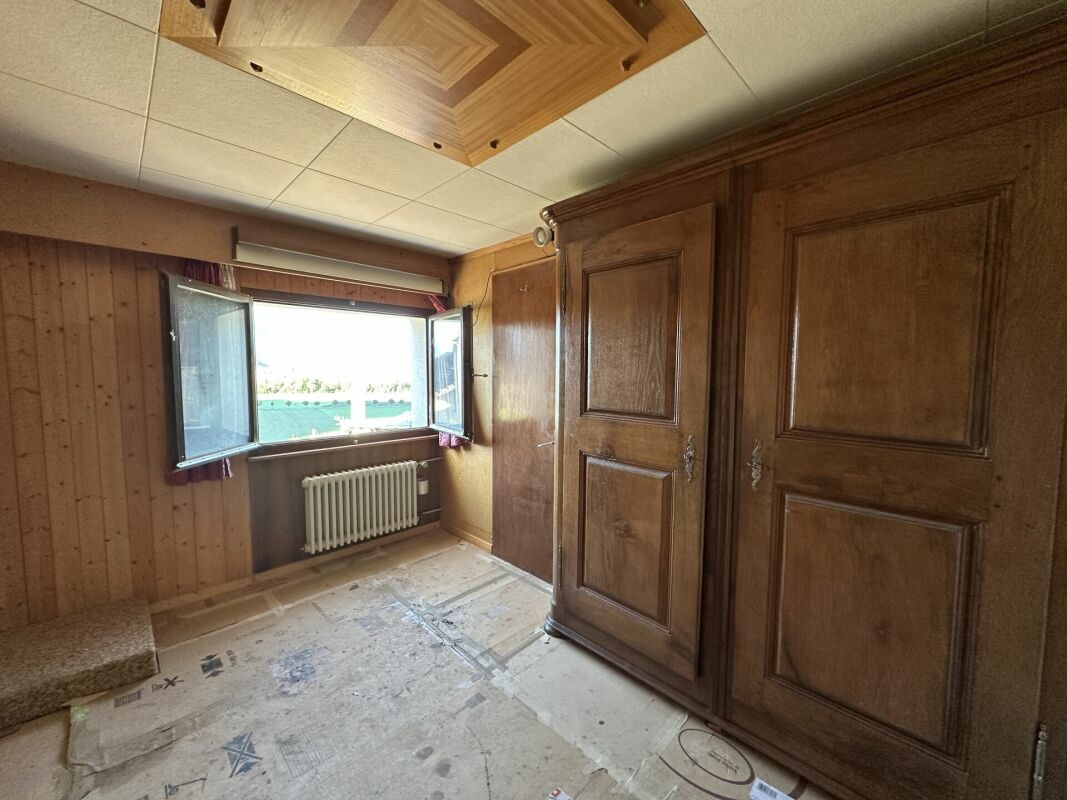 Holzvertäfelter Raum mit offenem Fenster und Einbauschrank