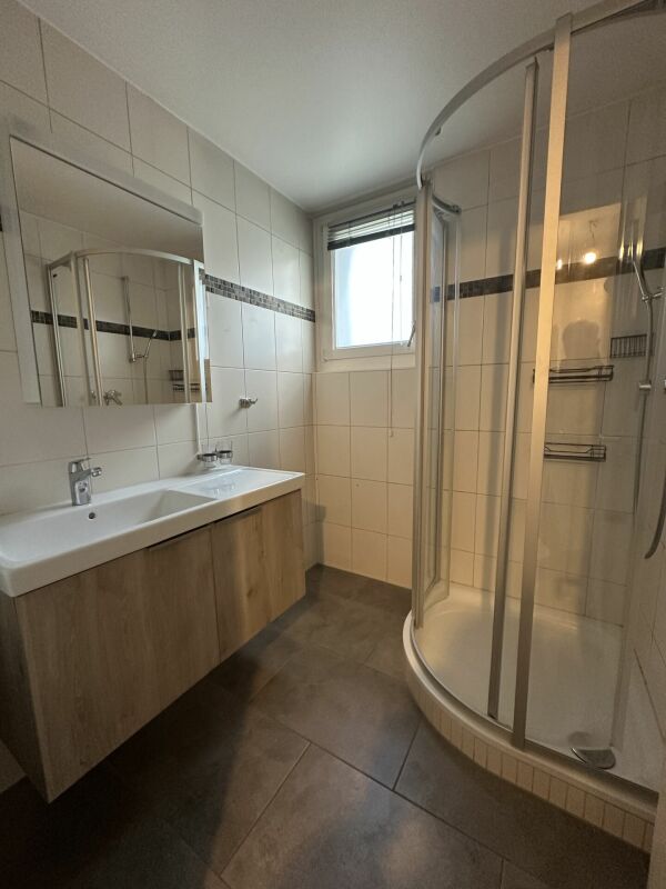Badezimmer mit Eckdusche und Waschtisch