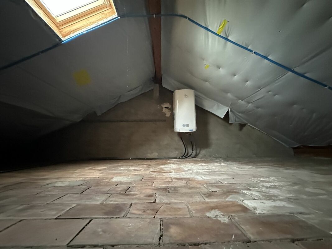 Dachboden mit sichtbarer Dämmung und Dachflächenfenster