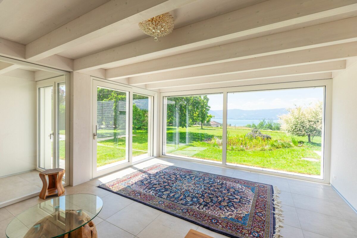 Heller Wohnraum mit Panoramafenstern und Seeblick