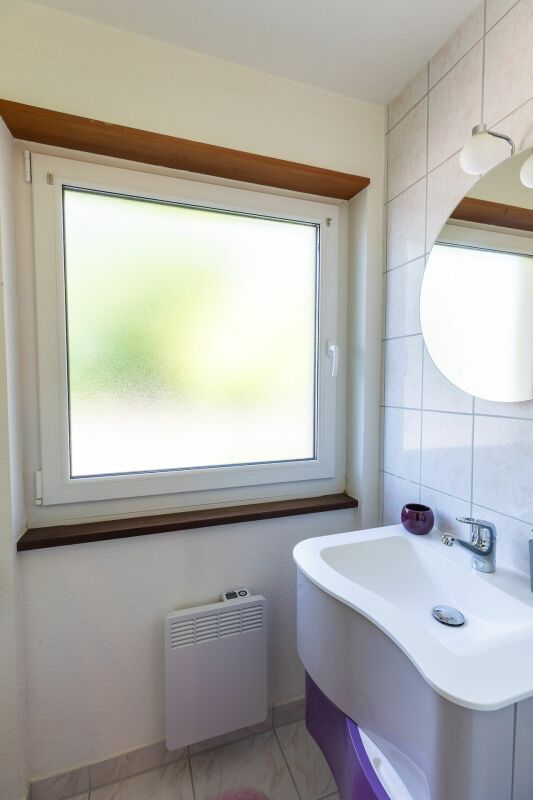 Kleines Badezimmer mit Fenster und Waschtisch