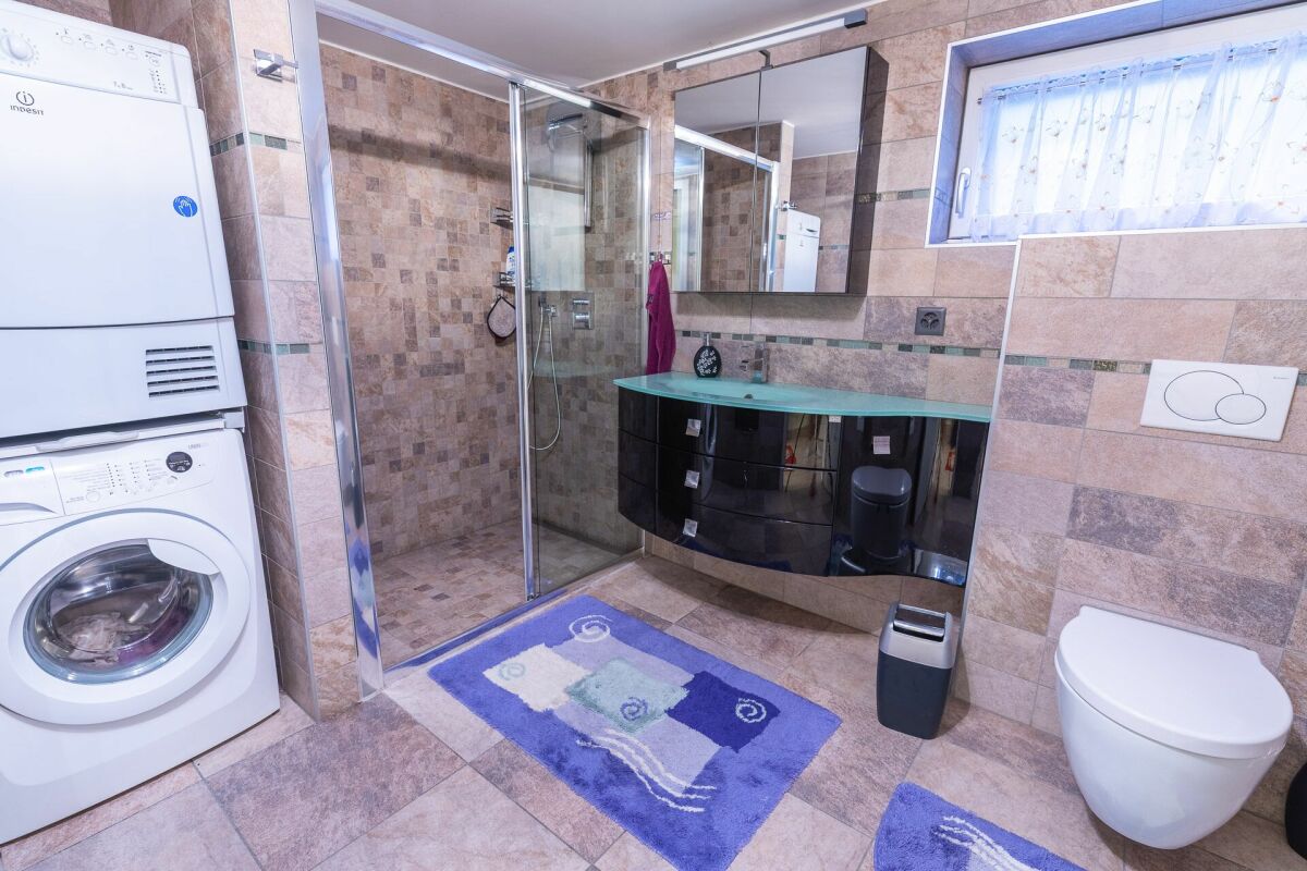 Modernes Bad mit Dusche, Waschmaschine und WC