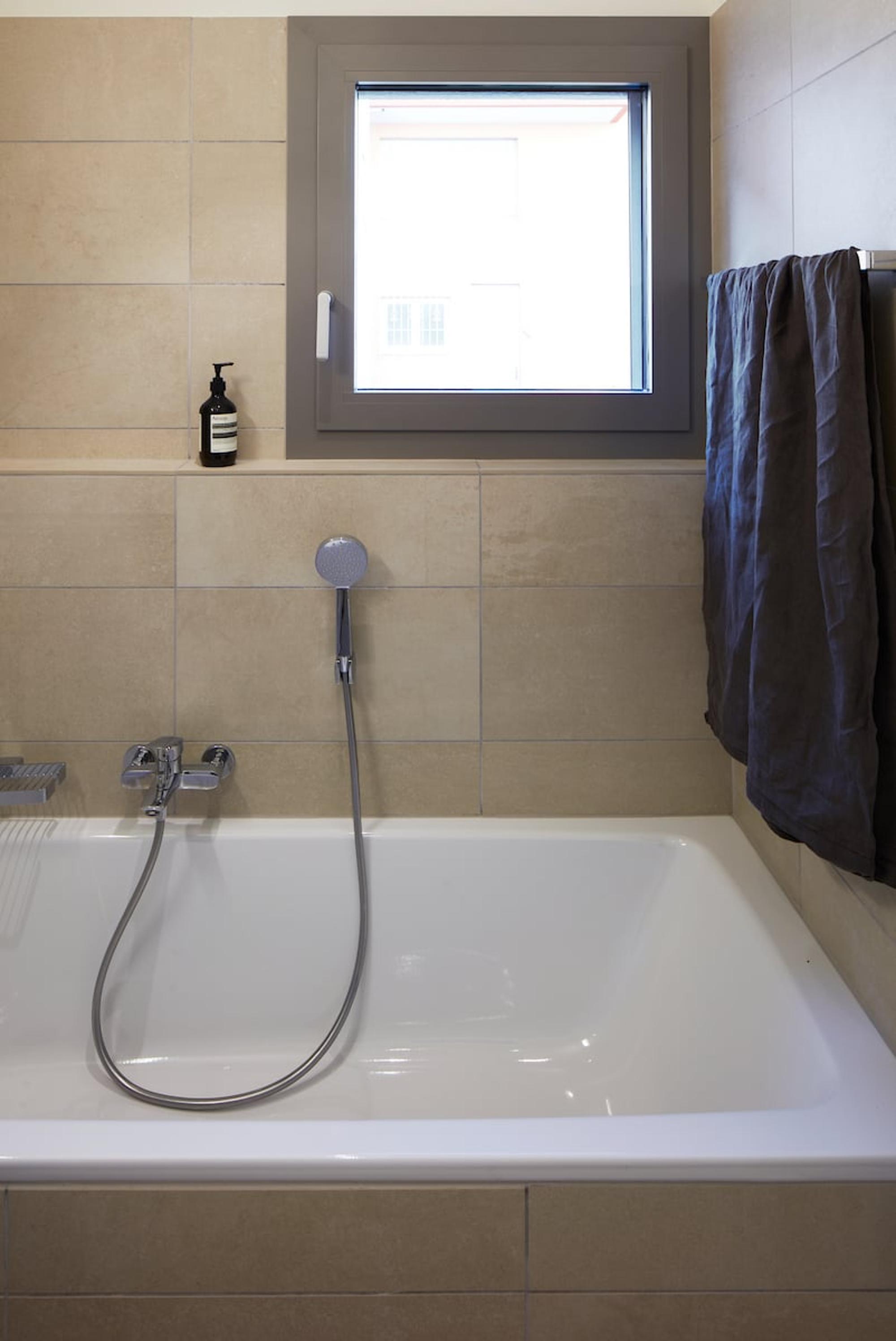 Modernes Bad mit Badewanne und Fenster