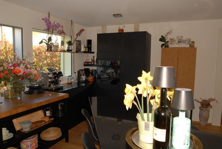Offene Küche mit dunklen Fronten und Blumen
