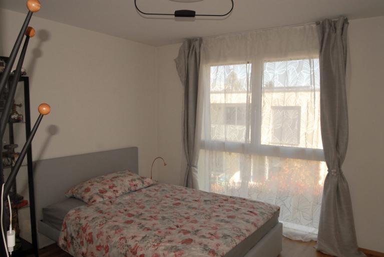 Schlafzimmer mit Bett und großem Fenster