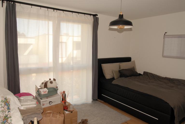 Schlafzimmer mit Fensterfront und Bett