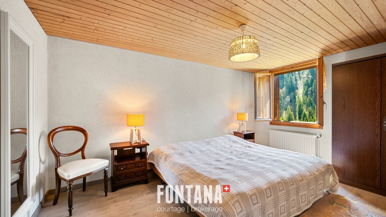 Gemütliches Schlafzimmer mit Holzdecke und Bergblick