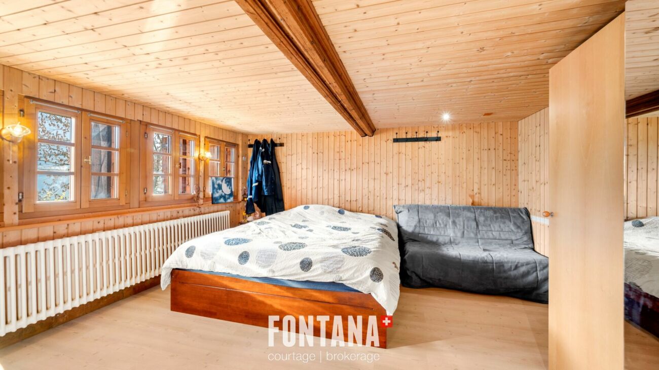 Holzvertäfeltes Schlafzimmer mit Bett und Fensterreihe