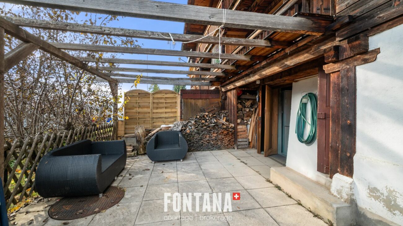 Überdachte Terrasse mit Sitzbereich und Holzstruktur