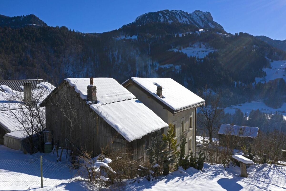 Verschneite Berghäuser mit Alpenpanorama