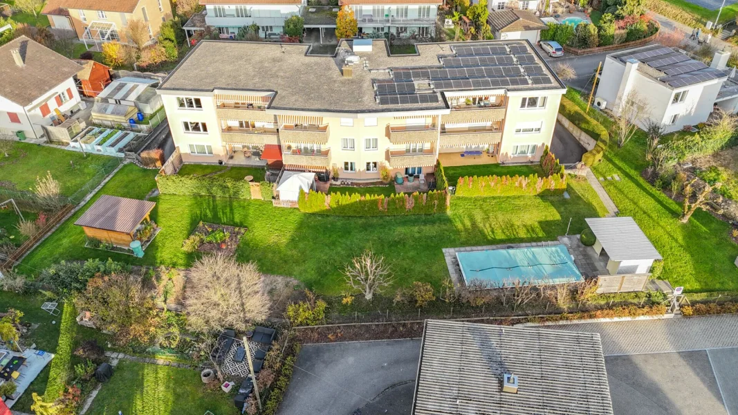 Aerialaufnahme eines Wohngebäudes mit großem Garten und Pool