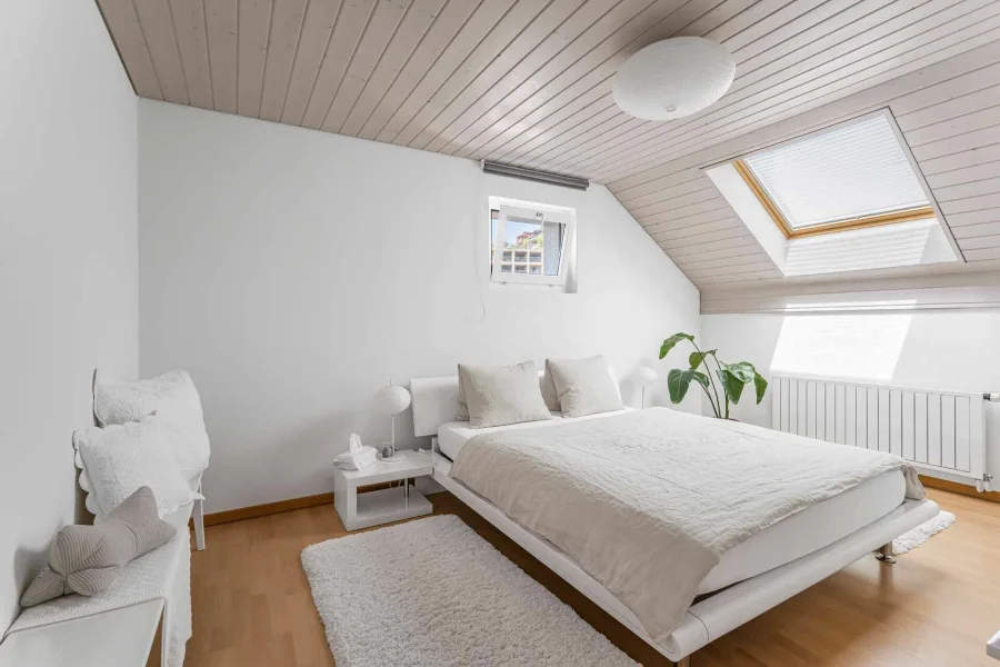 Helles Schlafzimmer mit Dachschrägen und Dachfenstern