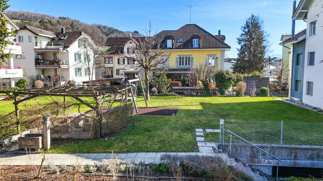 Garten mit Wohnhäusern im Hintergrund