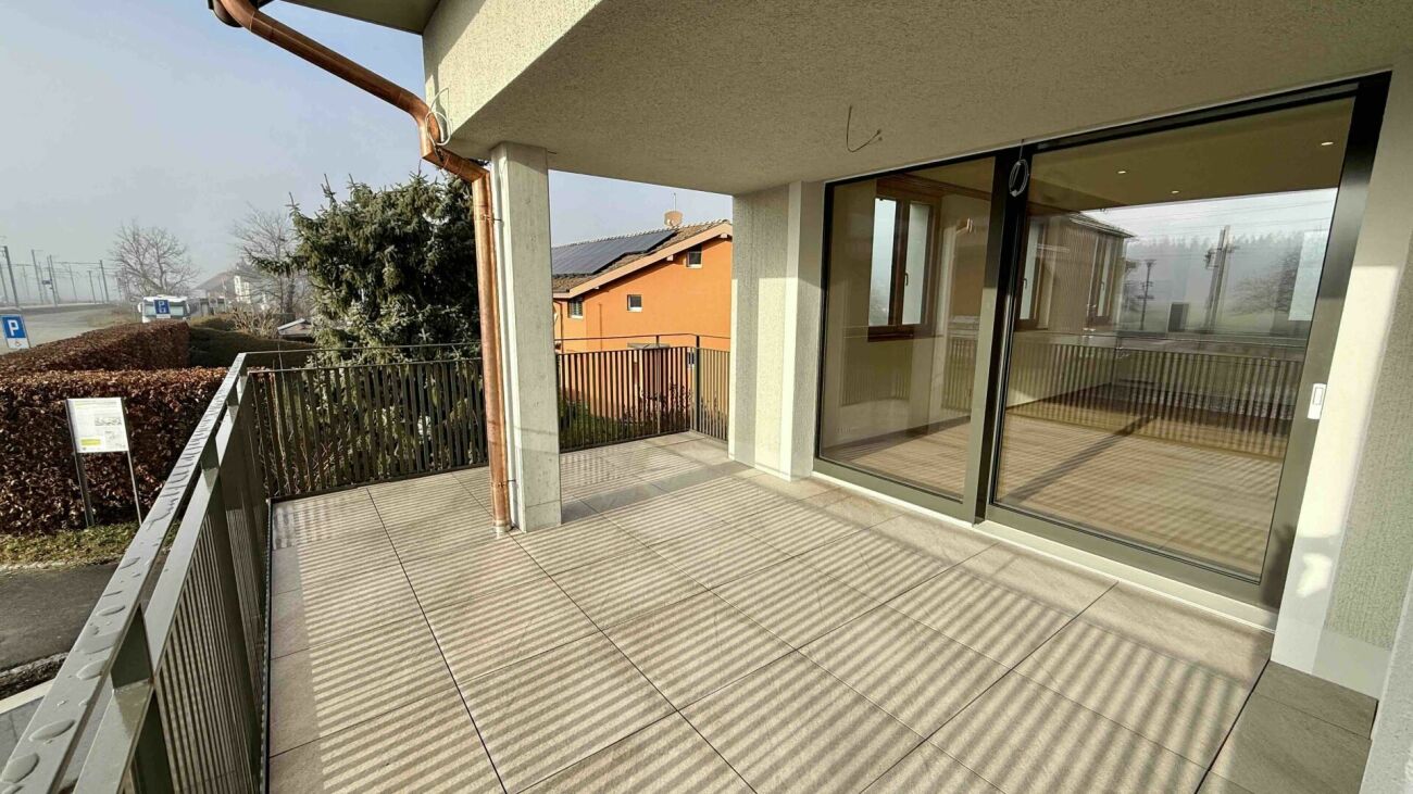 Balkon mit Glasfront und Blick ins Umfeld