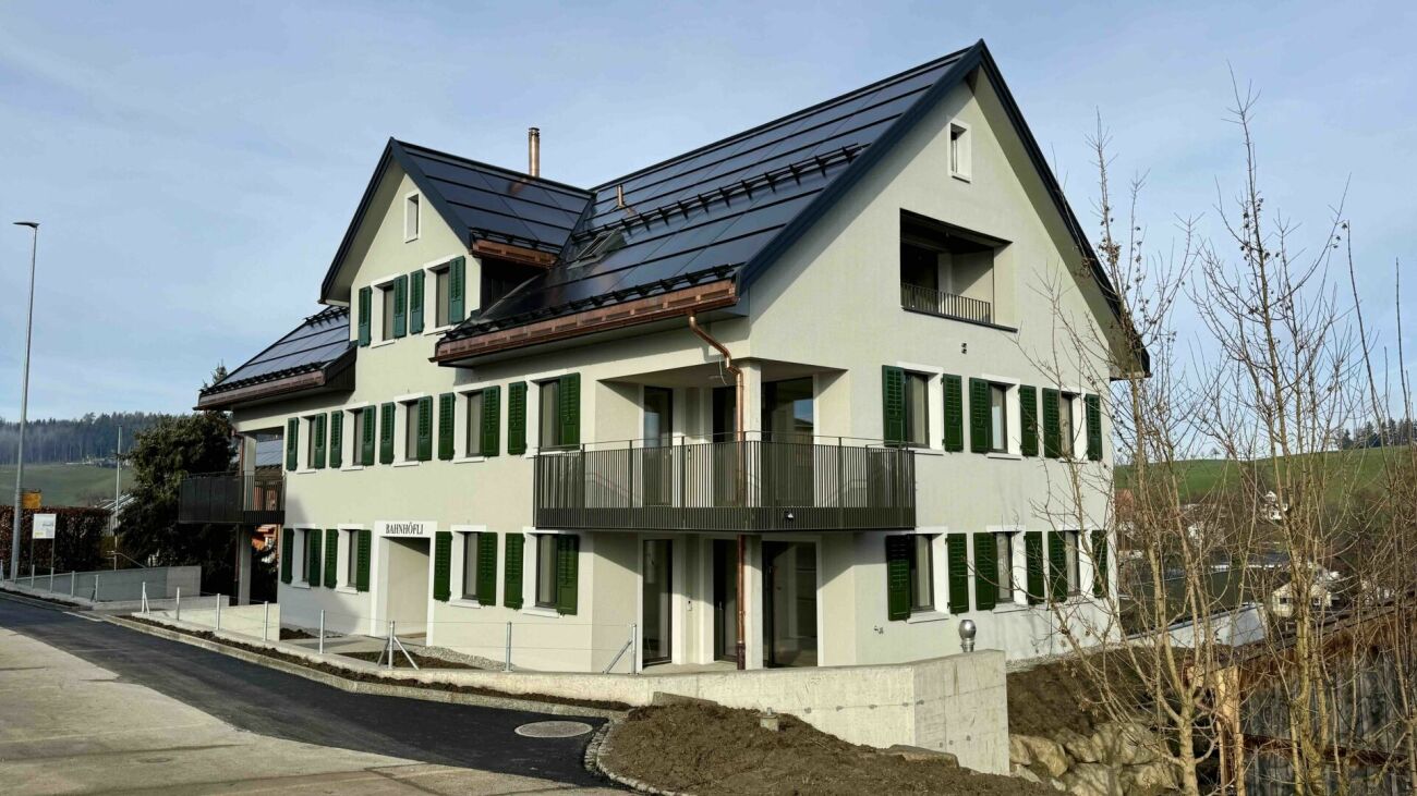 Mehrfamilienhaus mit Satteldach und grünen Fensterläden