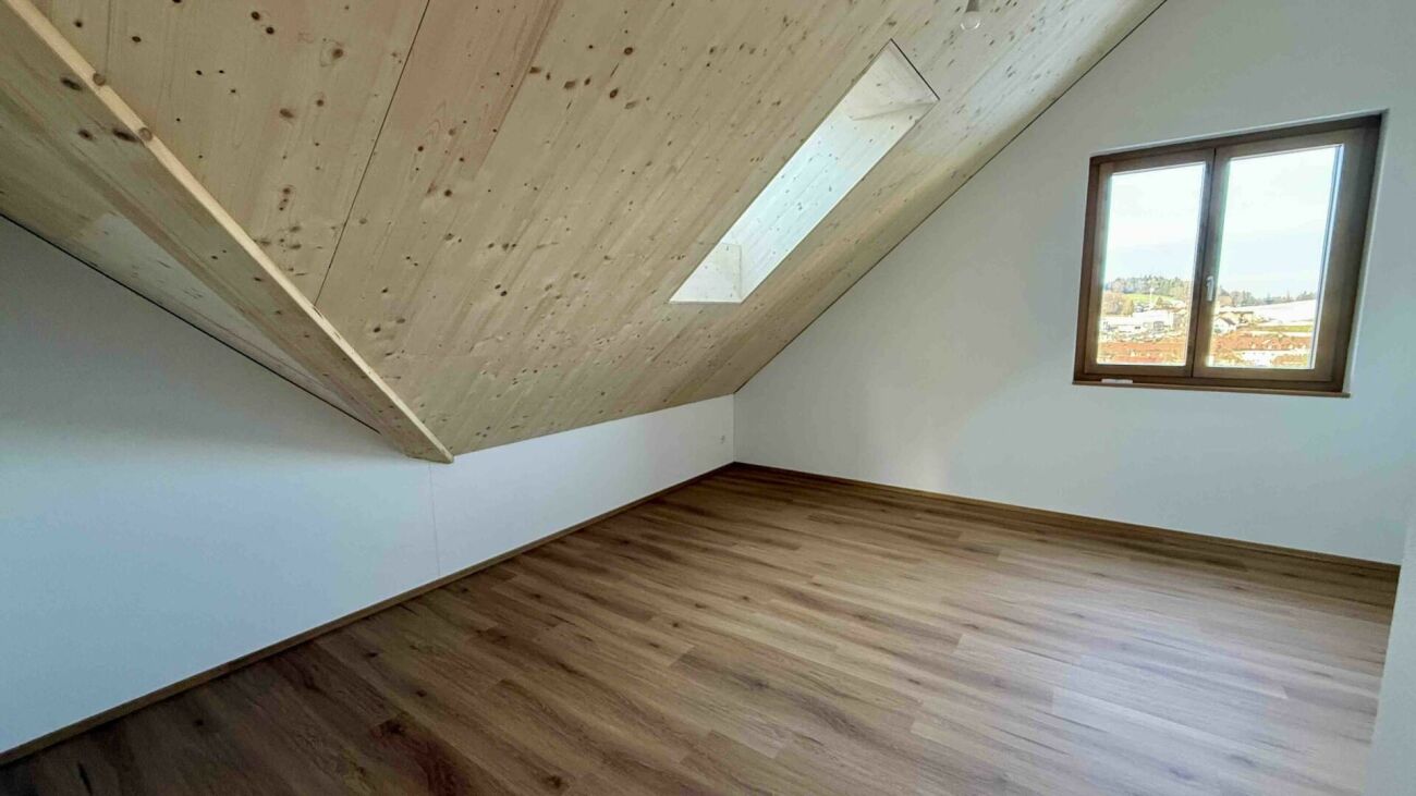 Dachzimmer mit Holzboden und Dachfenstern