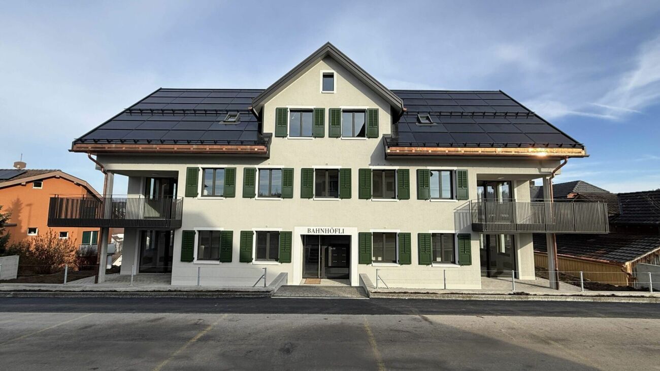 Wohnhaus mit Schrägdach und grünen Fensterläden
