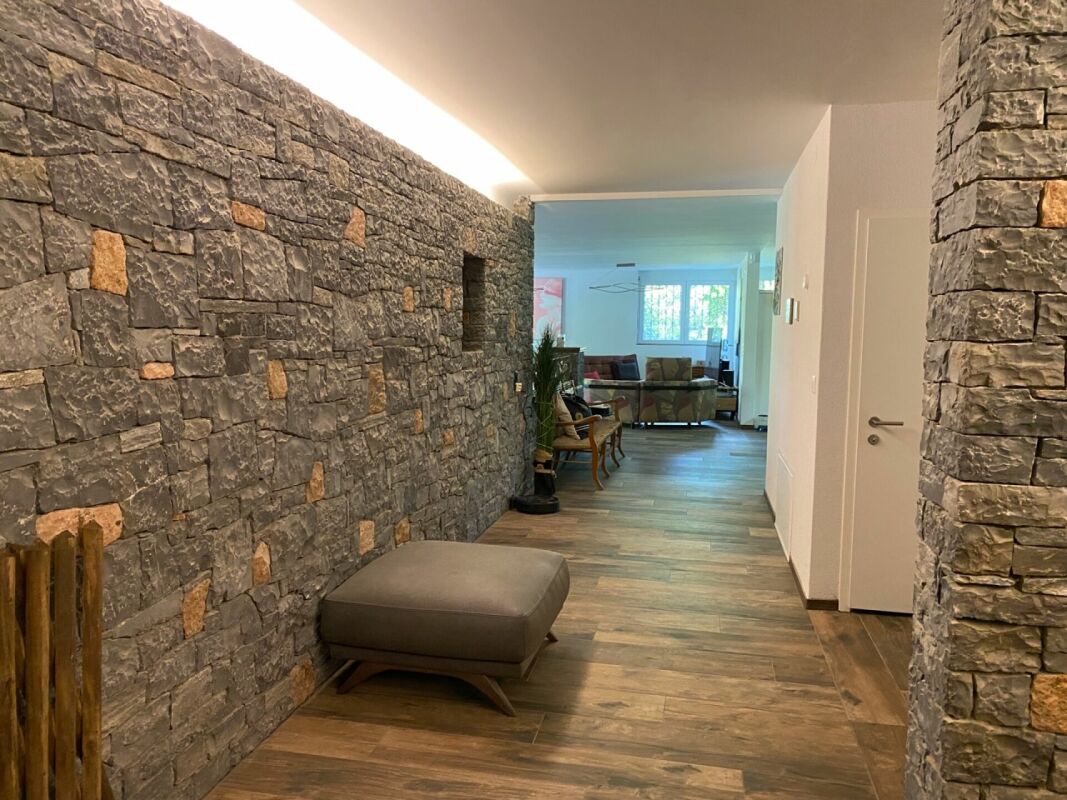 Moderner Flur mit Natursteinwand