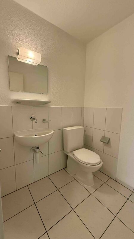 Gäste-WC mit Wandwaschbecken und Toilette