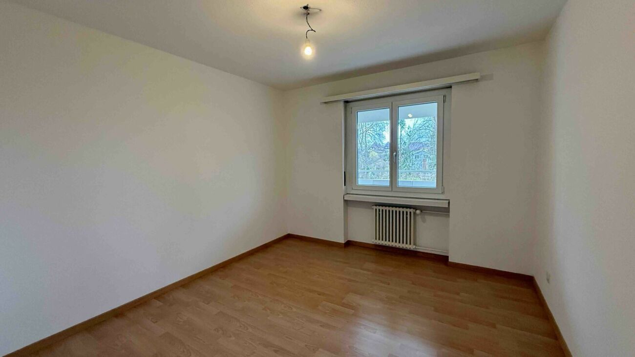Heller leerer Raum mit Holzfußboden und Fenster