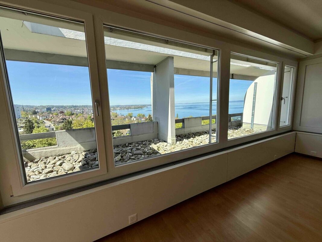 Wohnraum mit Panoramafenstern und Seeblick