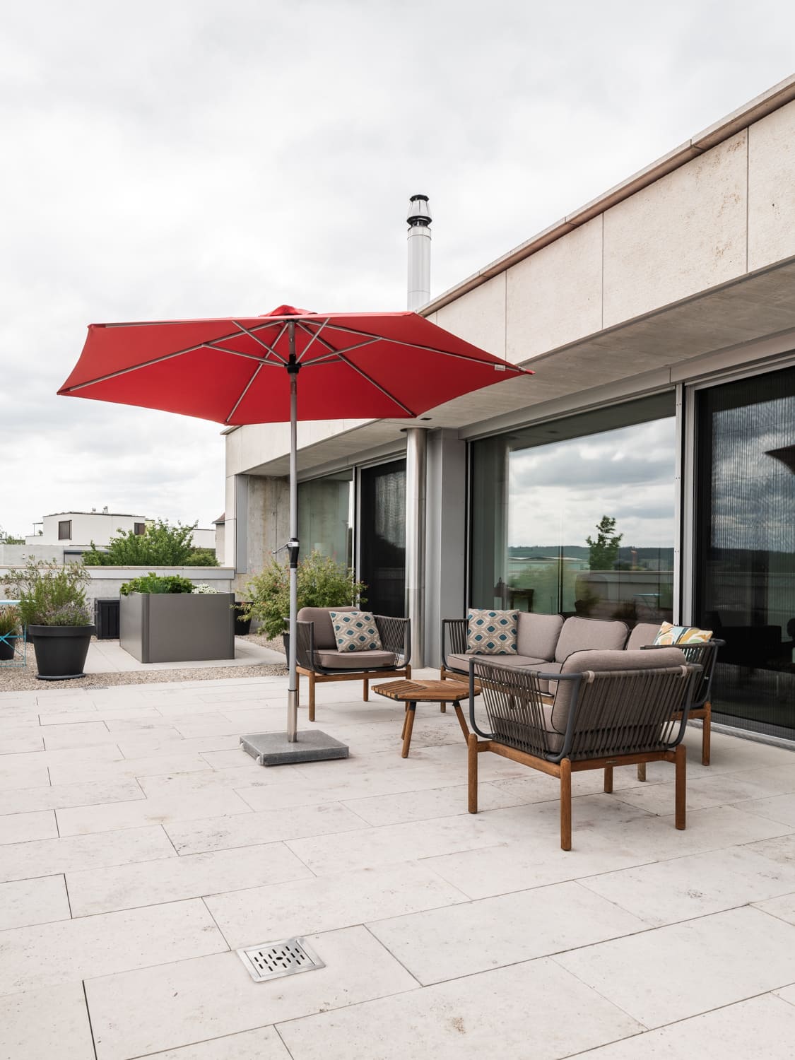 Dachterrasse mit Sitzgruppe und großem Sonnenschirm