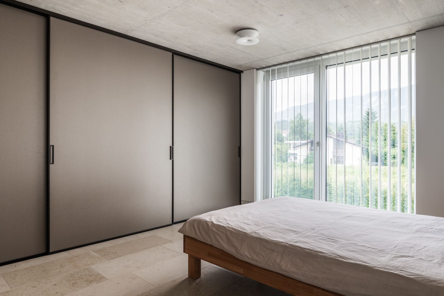 Modernes Schlafzimmer mit großem Fenster und Einbauschrank