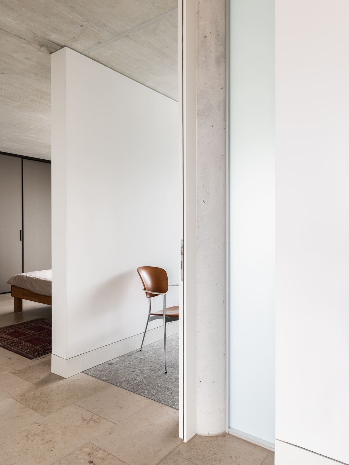 Minimalistisches Schlafzimmer mit Sichtbeton und Naturstein