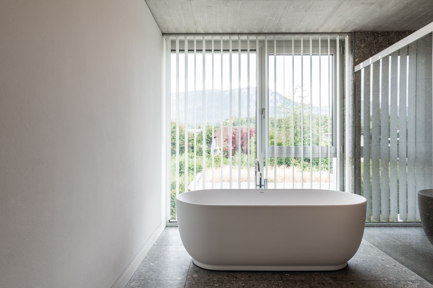 Modernes Badezimmer mit Badewanne vor Panoramafenster