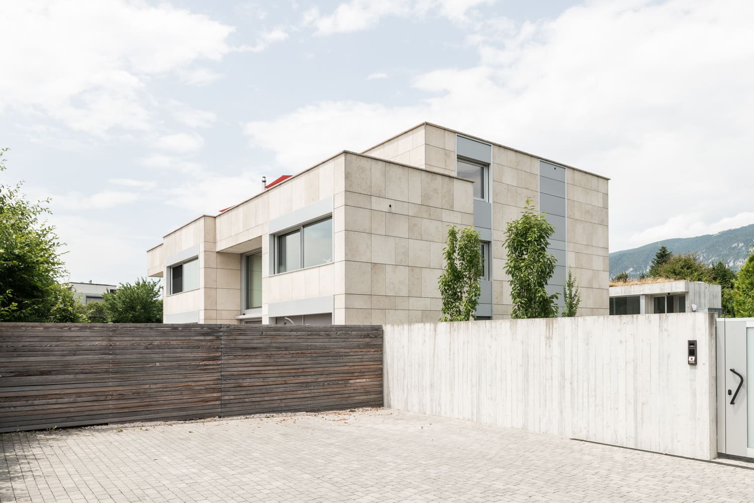 Moderne Außenansicht mit Zufahrt und Einfriedung