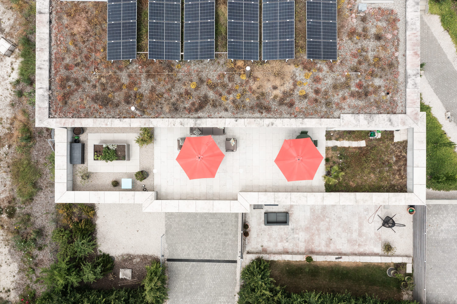 Drohnenaufnahme einer Dachterrasse mit Solarpaneelen und Außenbereichen