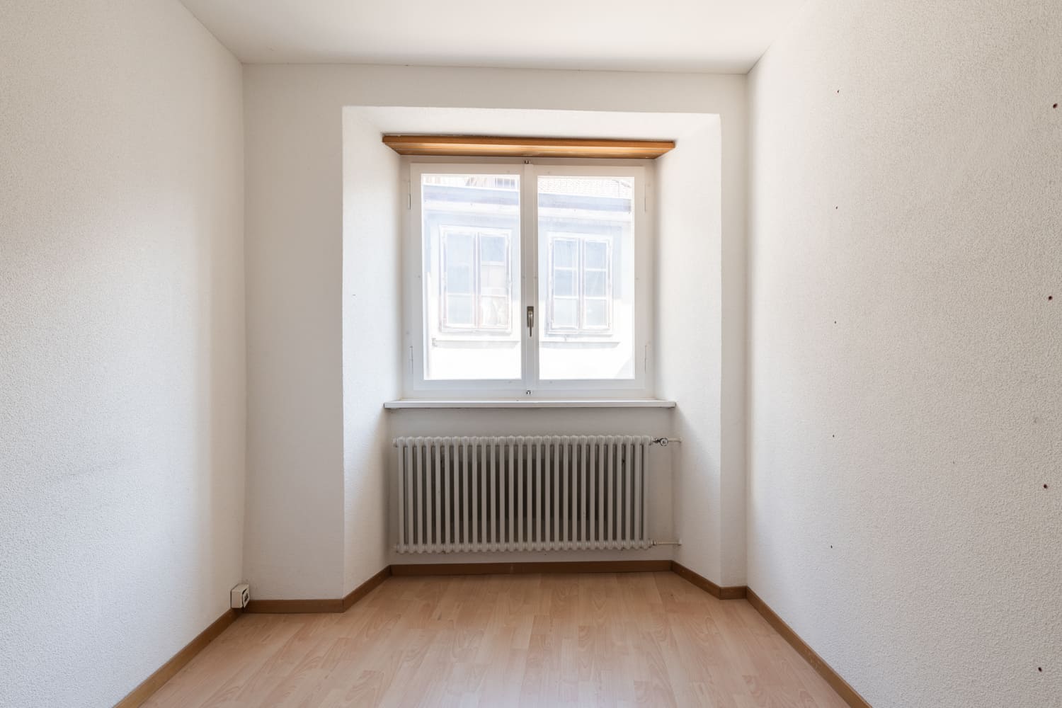 Kleiner leerer Raum mit Fenster und Heizkörper