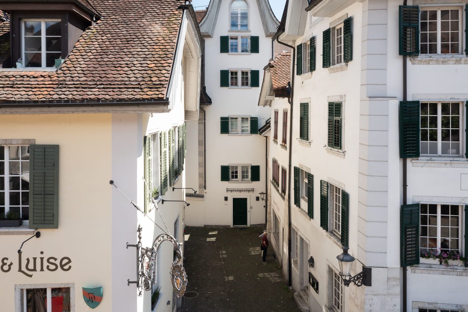 Historische Altstadt mit weißen Fassaden und grünen Fensterläden