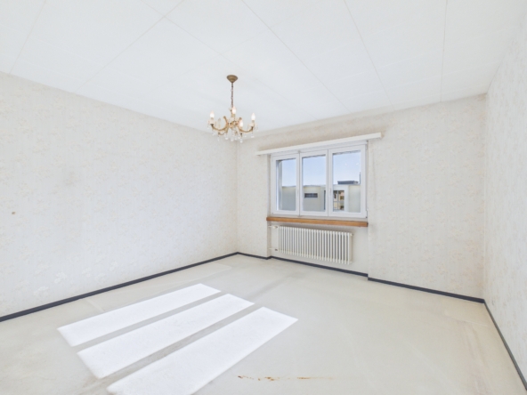 Leerer heller Raum mit Fenster und Kronleuchter