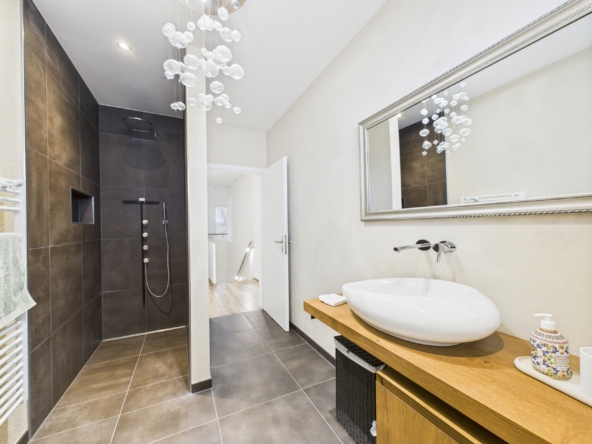 Modernes Badezimmer mit bodengleicher Dusche und Waschtisch