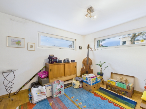 Kleiner Raum mit hoher Fensterbank und Spielzeugteppich