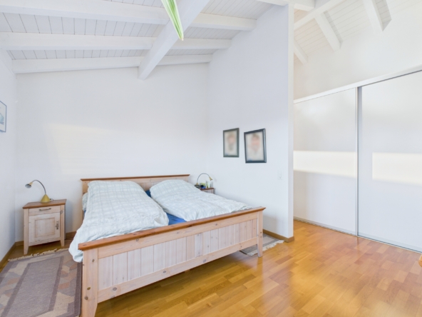 Helles Schlafzimmer mit Holzbett und Schrankeinbau