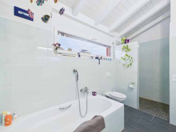 Helles Badezimmer mit Badewanne und WC