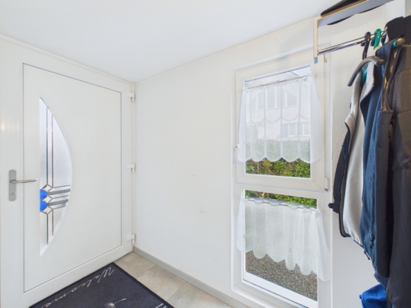 Heller Eingangsbereich mit Tür und Garderobe